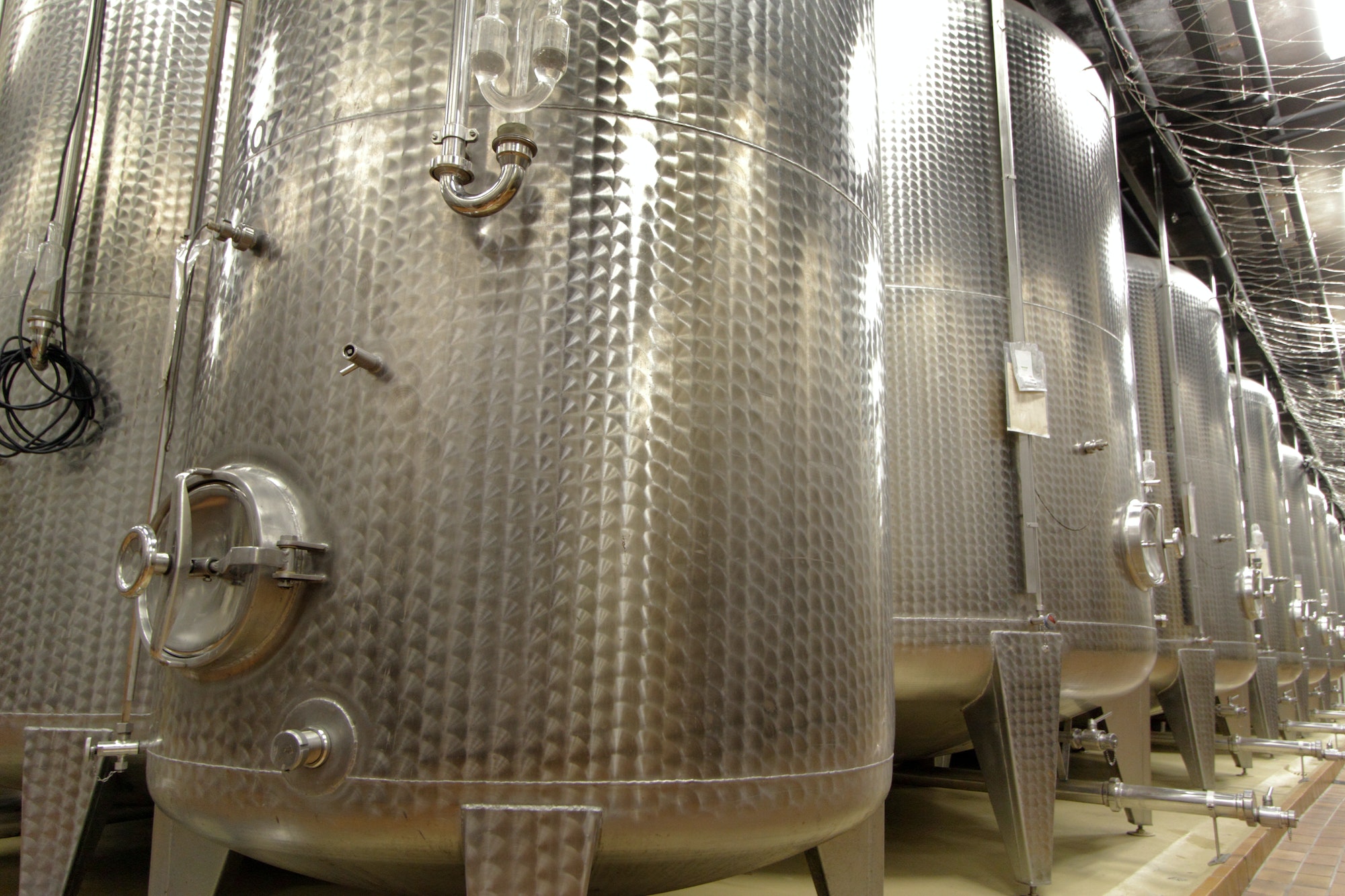 Stainless steel vats on industrial wine cellar